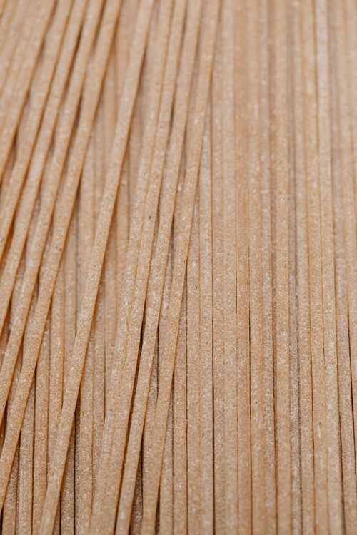 Free Top view composition of uncooked Italian tagliolini pasta heaped on table in light kitchen Stock Photo