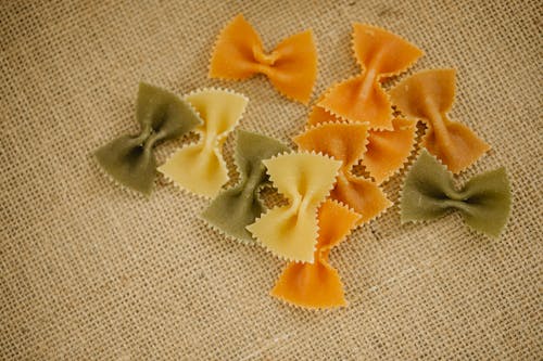 Scattered multicolored farfalle pasta on table