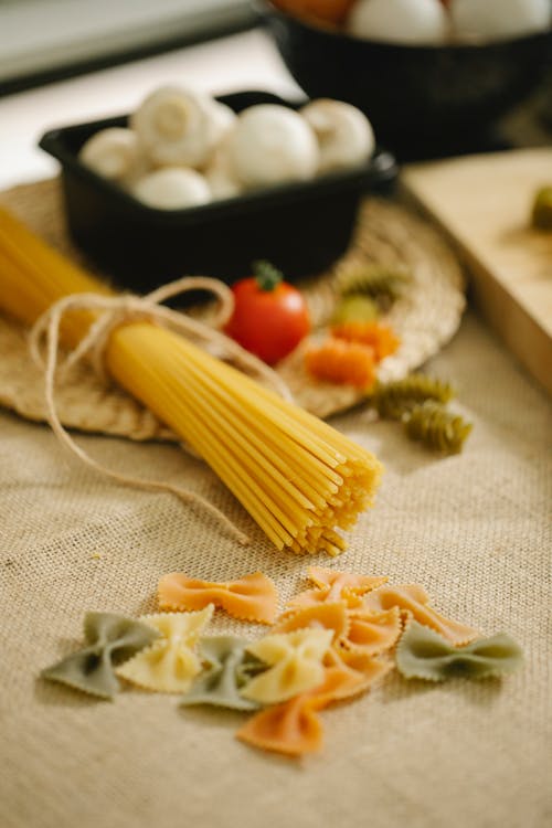 Raw pasta and mushrooms placed on table