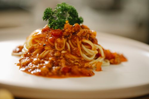 Free Tasty spaghetti with yummy bolognese sauce served on white plate and garnished with parsley Stock Photo