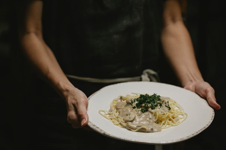 Person With Plate Of Pasta With Mushrooms