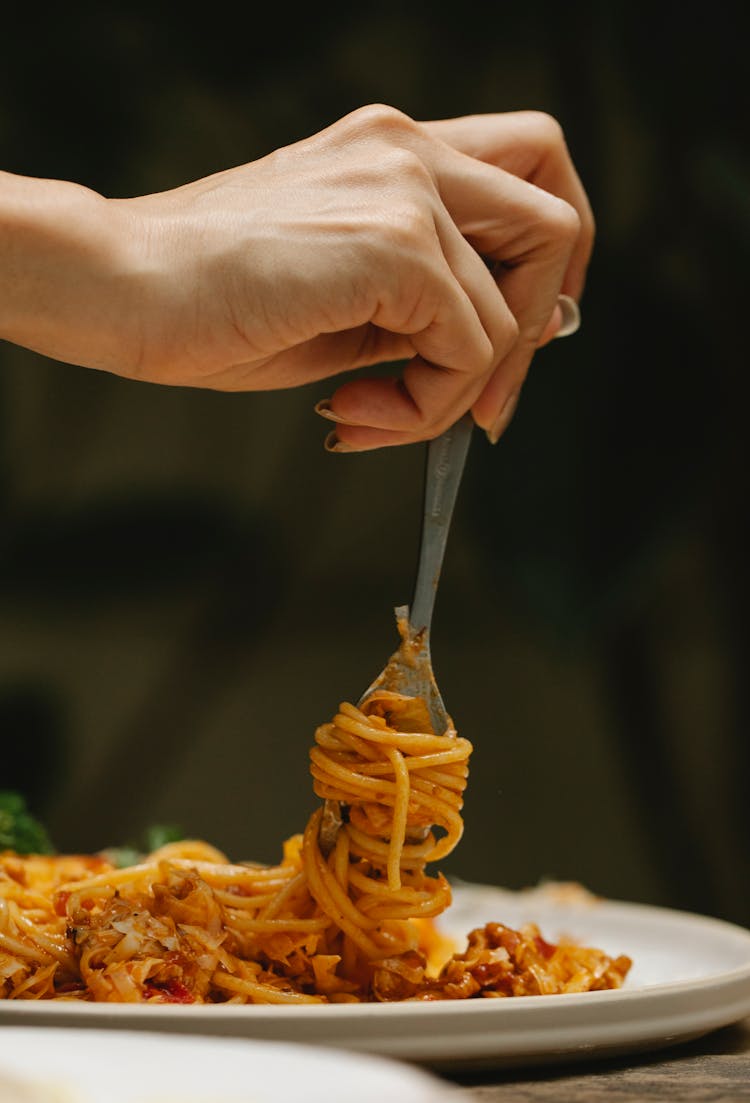 Crop Woman Rolling Spaghetti On Fork During Dinner In Restaurant