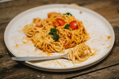 Delicious spaghetti with tomatoes and sauce served on wooden table