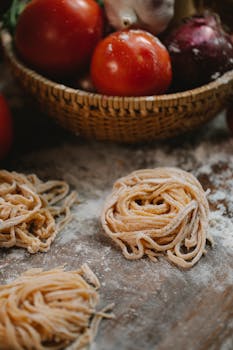 Homemade pasta nests with tomatoes and onions, perfect for an Italian meal.
