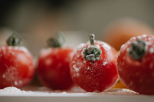 Free Fresh red tomatoes in flour prepared for cooking and covered with flour in kitchen in soft focus Stock Photo