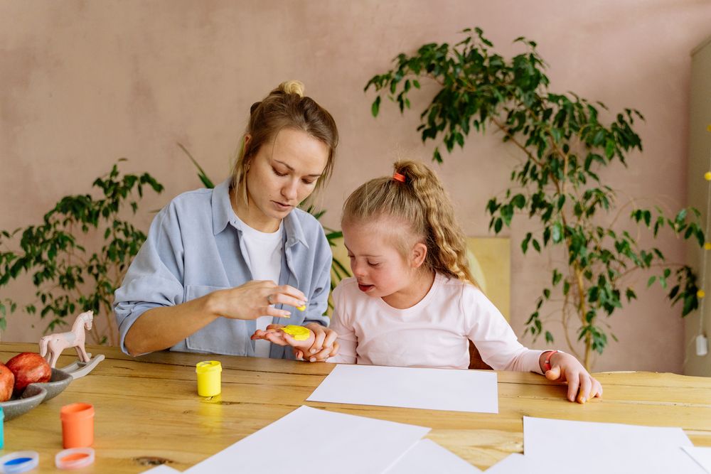 A therapist working through a tabletop activity with a young child at home