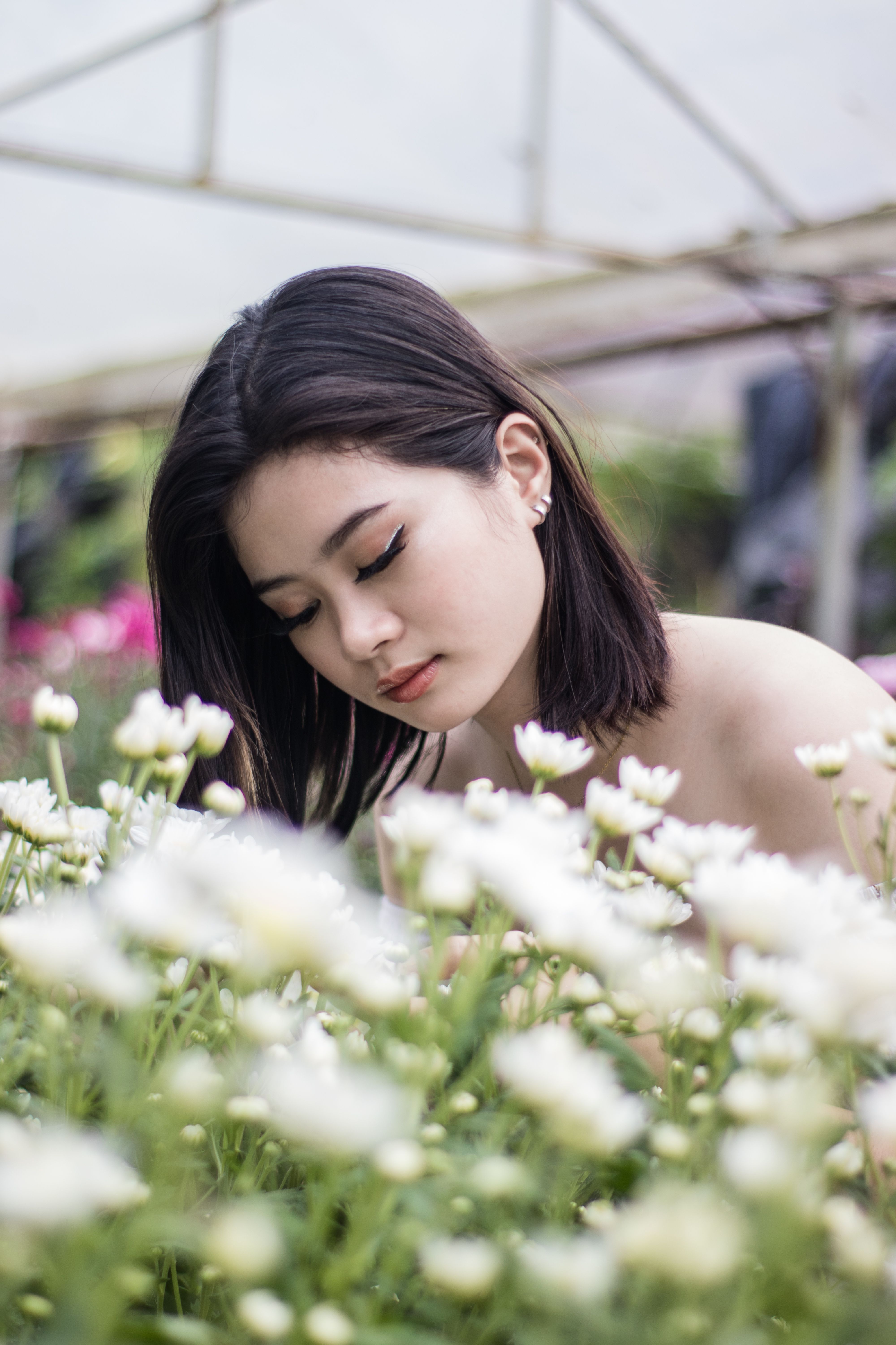 Serene portrait of a woman in a lush flower garden, showcasing natural beauty.
