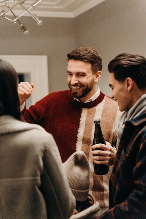 Free Joyful group of friends celebrating indoors with champagne and smiles, creating a warm festive atmosphere. Stock Photo