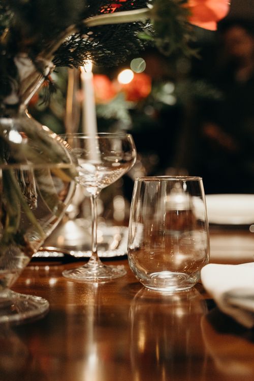 Free Close-up of elegant glassware on a beautifully decorated table with warm ambient lighting, perfect for festive gatherings. Stock Photo