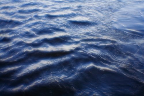 Free A serene and textured view of rippling blue water in natural light. Stock Photo