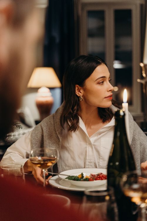 Free A woman elegantly dining with wine and candlelight, creating a warm and intimate ambiance. Stock Photo