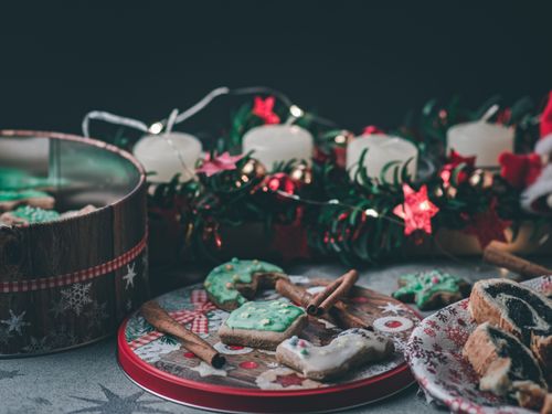 Free Close-up of Christmas cookies with festive candle and garland decorations for a cozy holiday atmosphere. Stock Photo