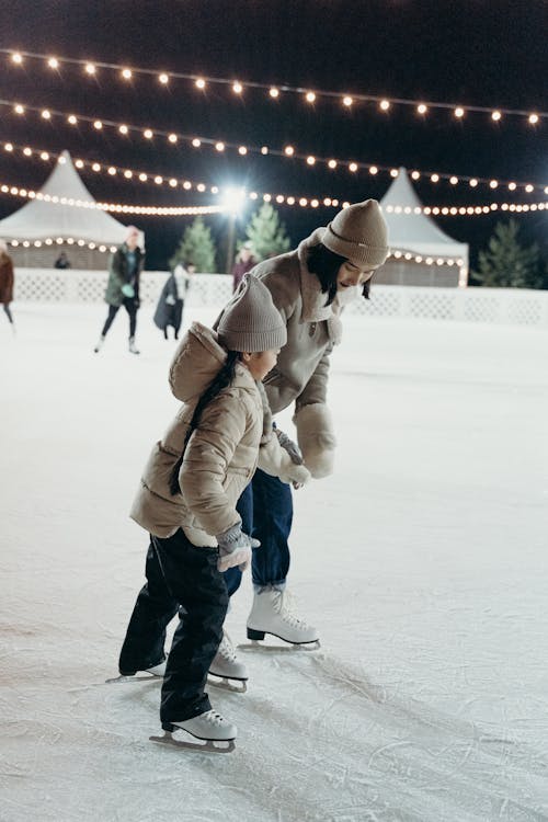 Woman and a Child wearing Beanies Ice Skating