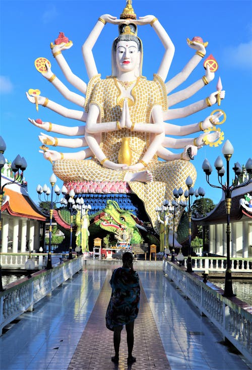 Free Woman Standing in Front of a Buddha Statue Inside the Temple Stock Photo