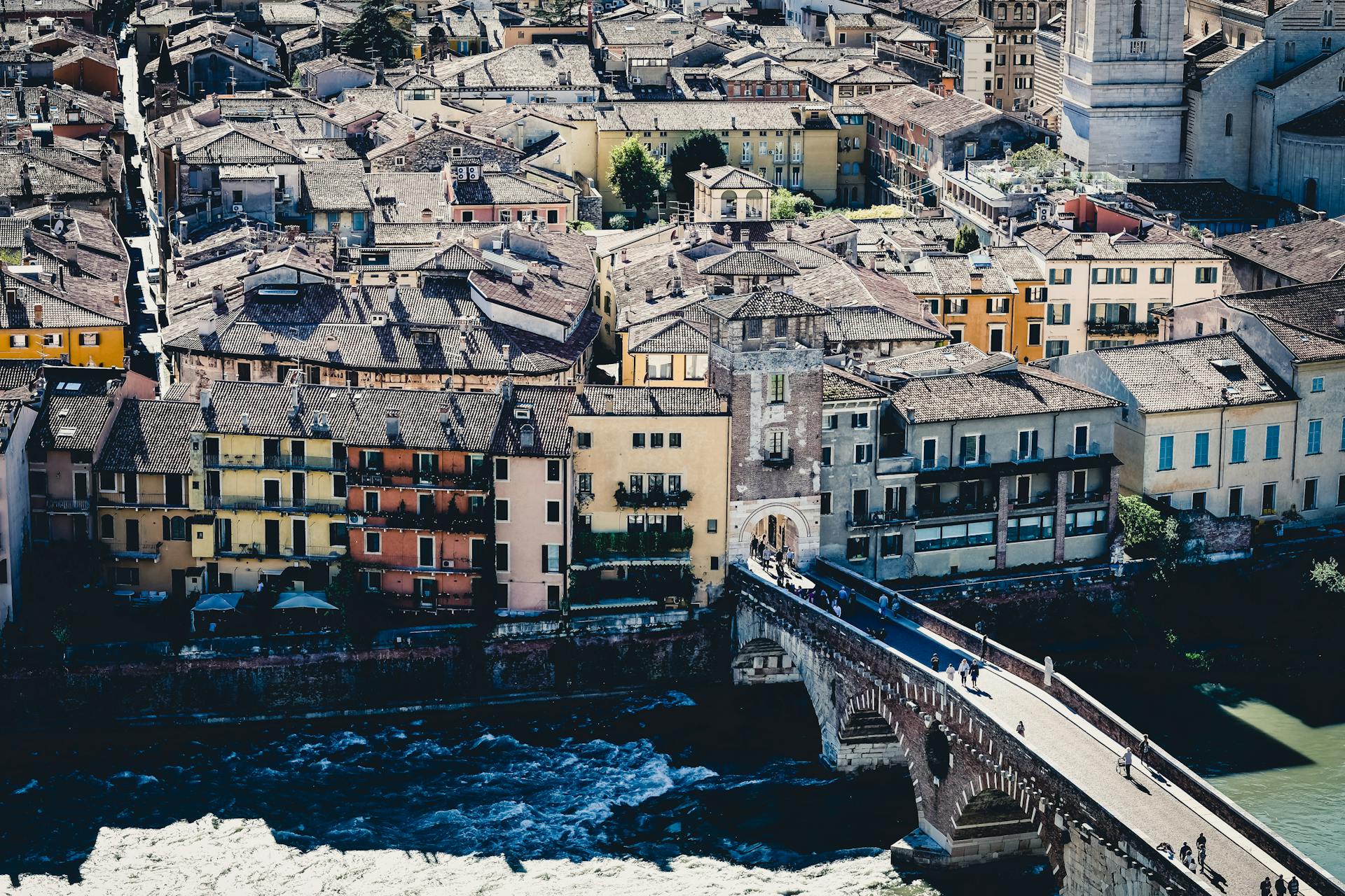 Aerial view of Verona's Ponte Pietra and historic cityscape showcasing Italian architecture.