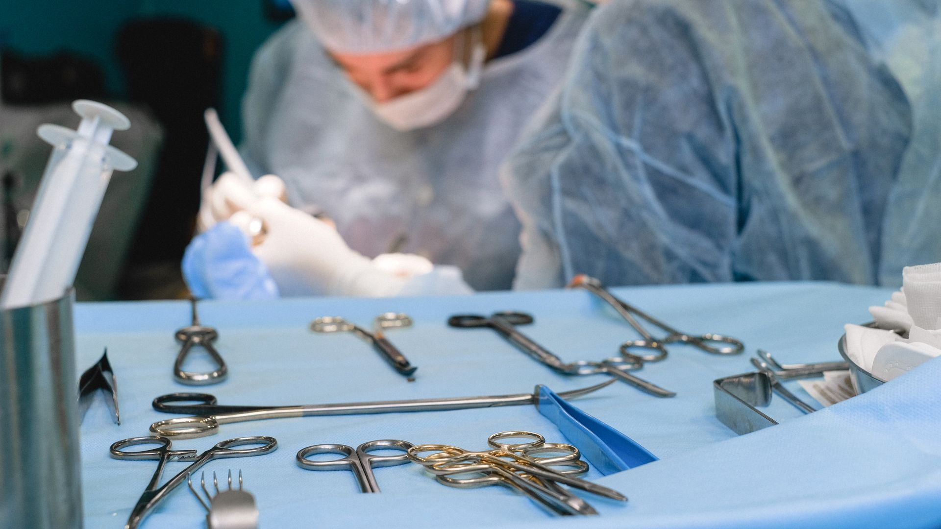 modafinil for surgeons: Is This Smart Drug the Answer to Surgical Fatigue? Close-up of surgical instruments on table with surgeons in the background preparing for surgery — modafinil for surgeons