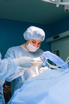 Female surgeon in operating room focused on procedure, wearing full surgical gear.