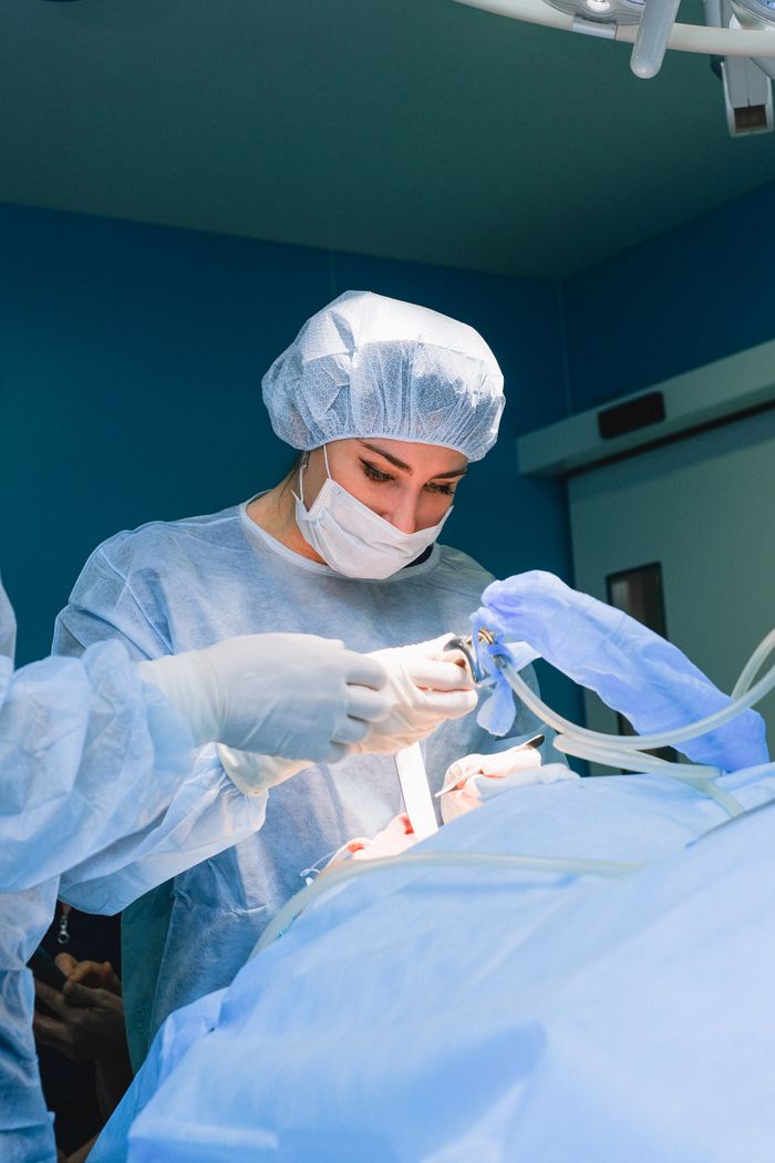 Female surgeon performing an operation in a sterile theatre