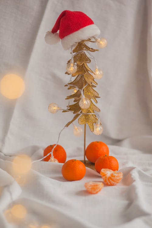 Small plastic Christmas tree with lanterns and tangerines