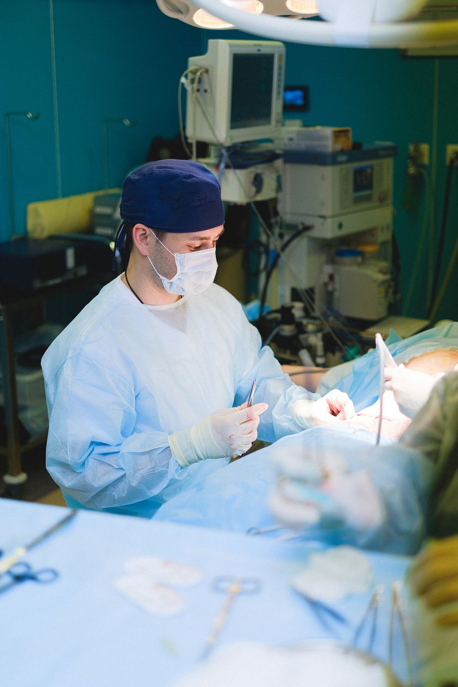A surgeon performing a procedure in a modern operating room with advanced equipment
