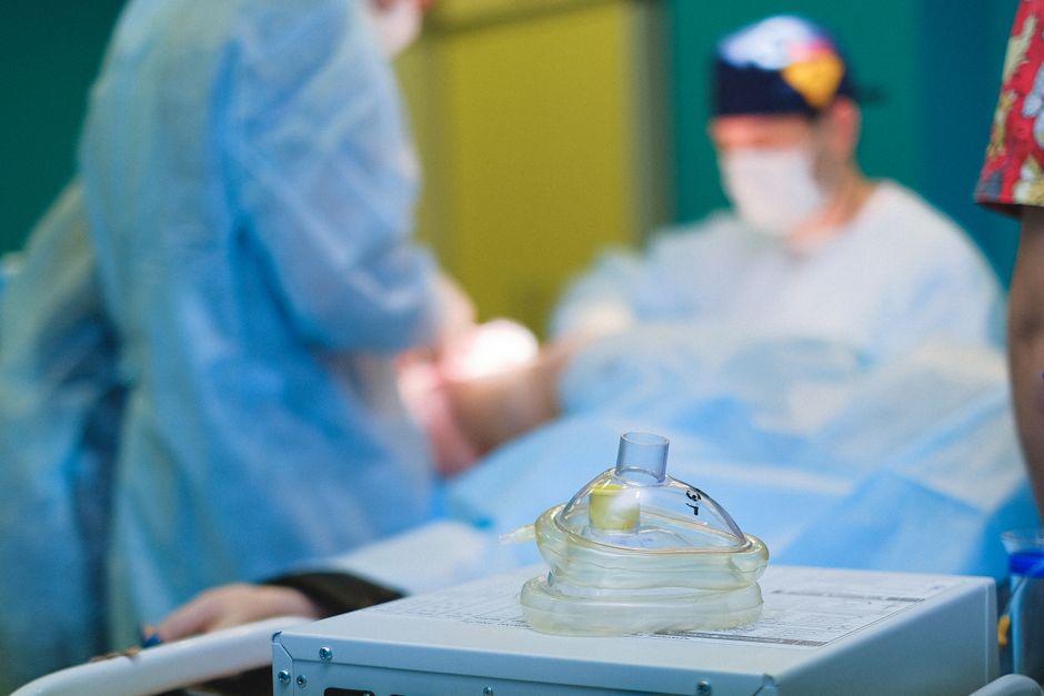 Medical team performing surgery in a sterile hospital operating room.