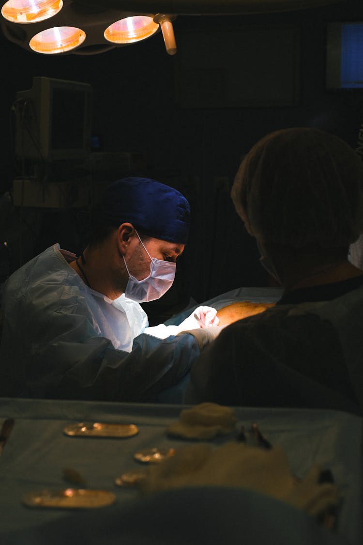 Surgeon In Dark Operating Room