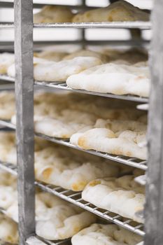Close-up of freshly baked bread cooling on racks in a bakery.