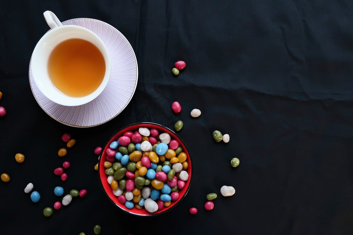 Free Assorted Candies Next to White Ceramic Cup and Saucer Stock Photo