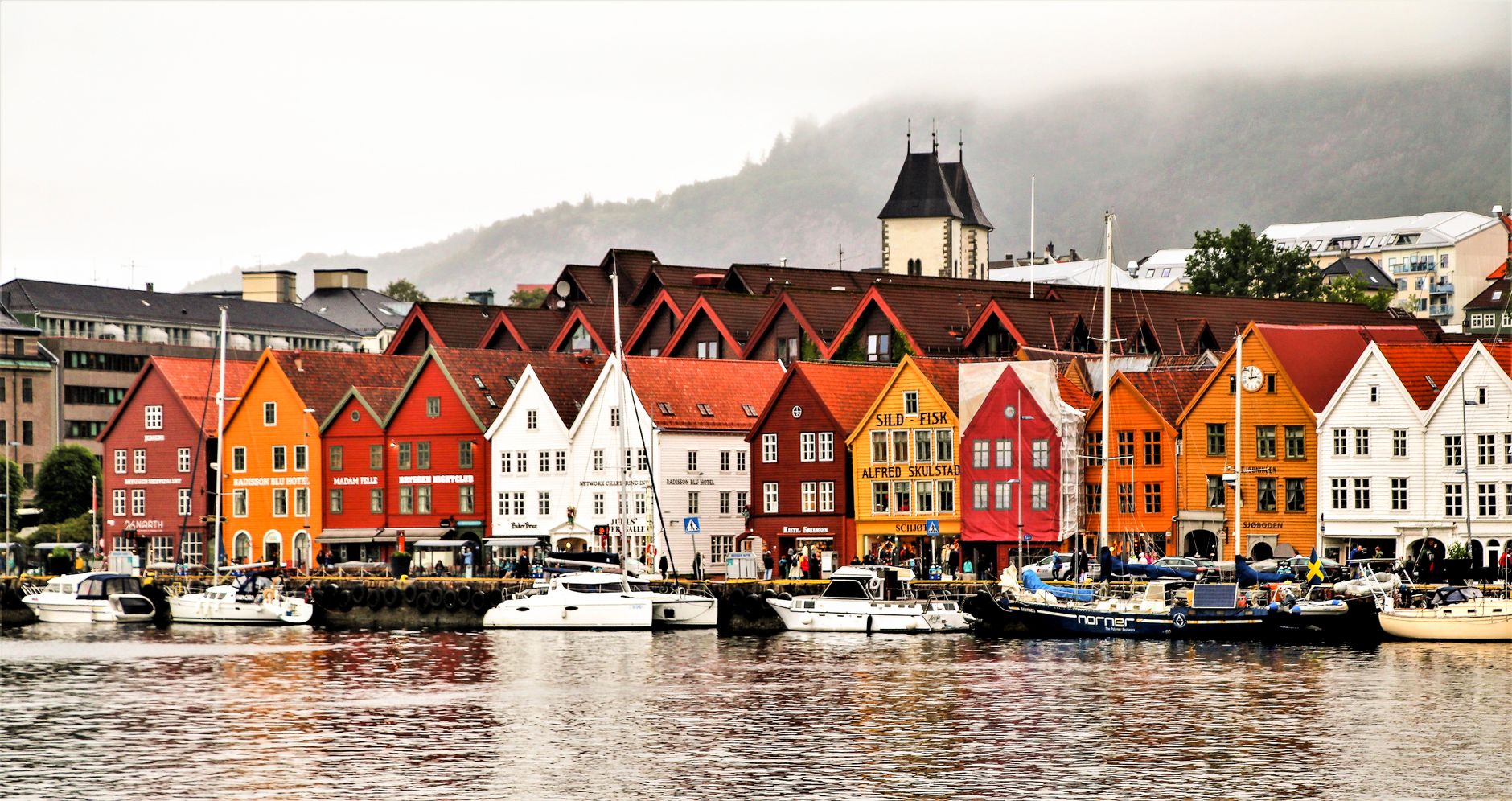 Charming waterfront of Bergen showcasing vibrant historic buildings and boats.. Photo by Marcelo Camargo Santos on Pexels