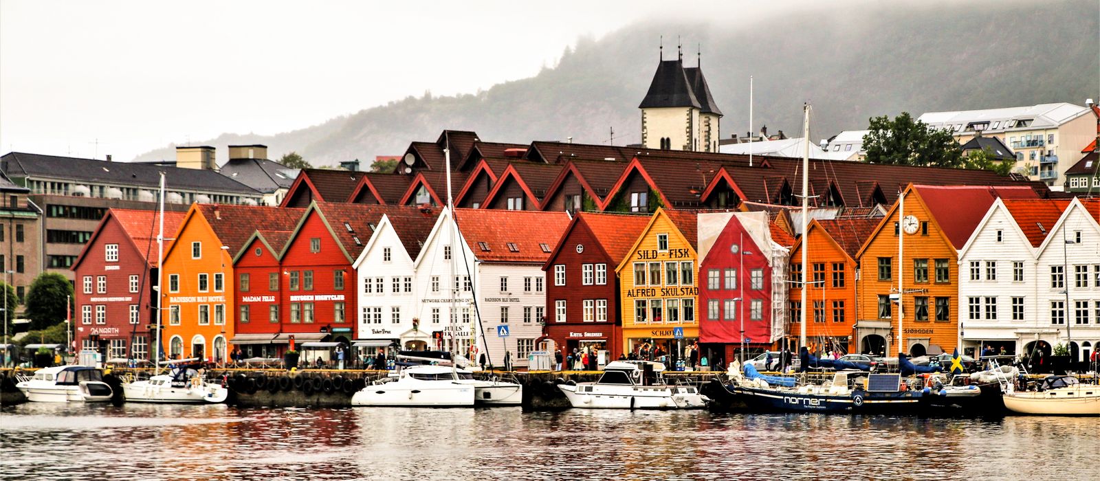 Charming waterfront of Bergen showcasing vibrant historic buildings and boats. — flights from Tromso to Bergen