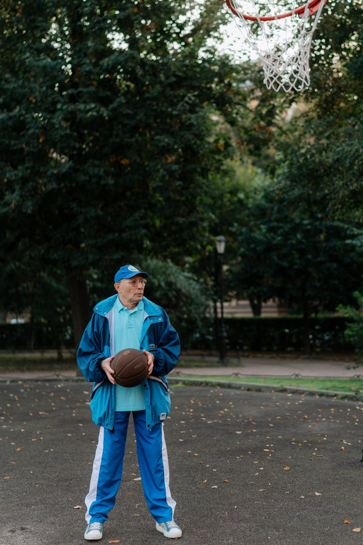 Man In Blue Tracksuit Playing Basketball