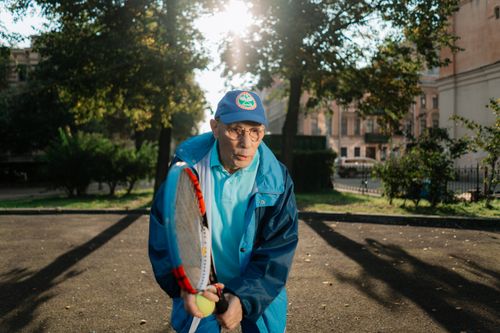 Free A senior man playing tennis outside, enjoying leisure activities in the park during the day. Stock Photo