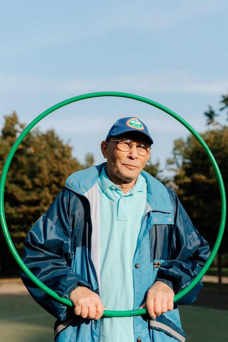 An Elderly Man Holding A Hula Hoop