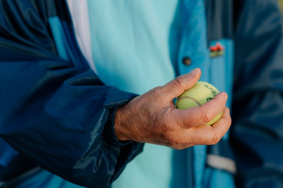senior hand squeezing tennis ball