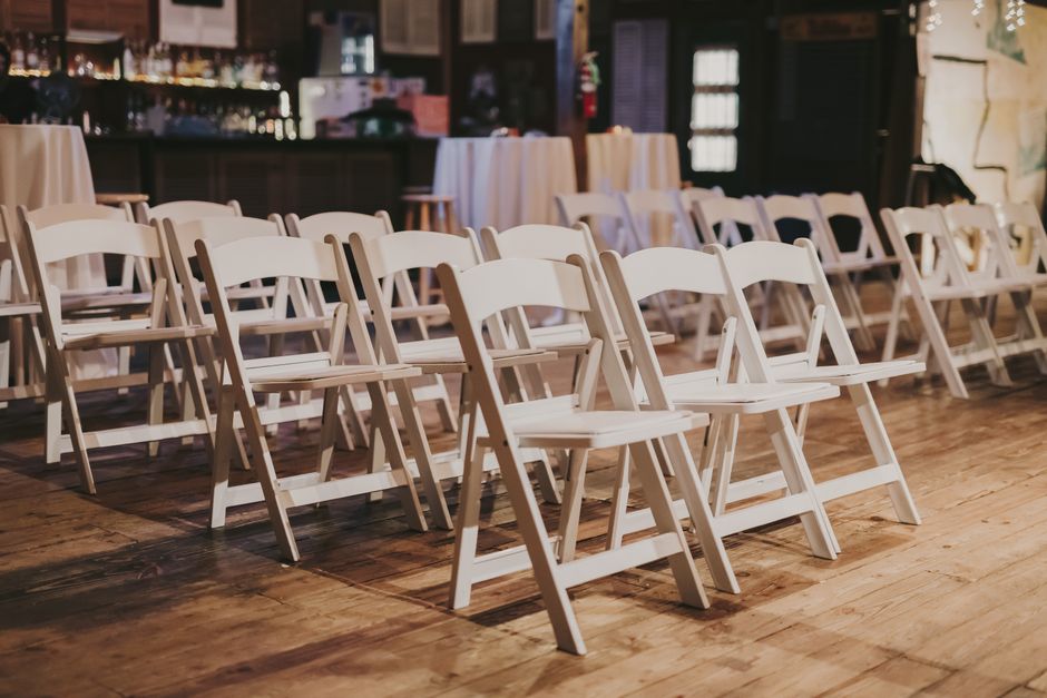 White folding chairs arranged in rows inside an event venue in Fresno-Armona