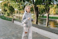 Elderly Woman in Gray Hoodie Sweater Jogging on Pavement