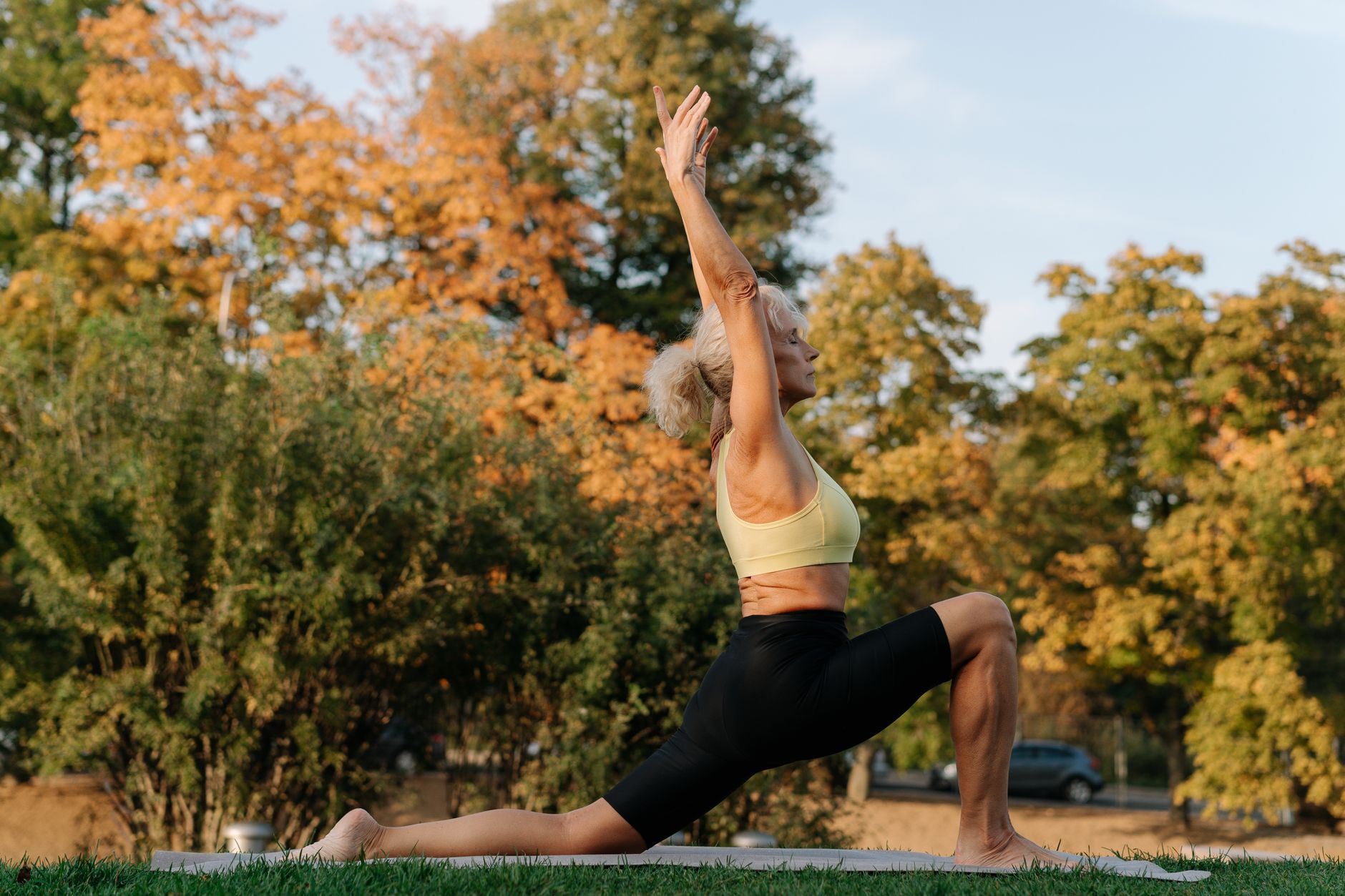 打造身心平衡:實用心理健康生活指南 Senior woman performing yoga in a park setting during autumn season.
