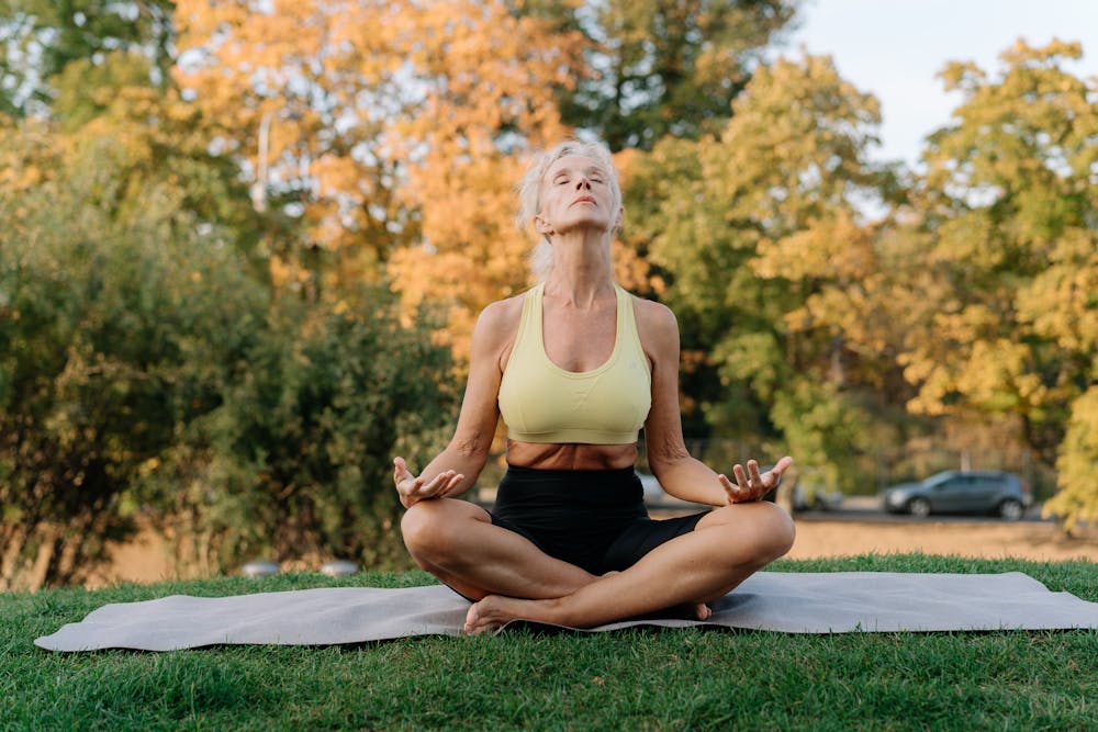 Woman meditating on grass outdoors
