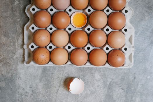 Top view of chicken eggs in rows in paper container placed on table for cooking
