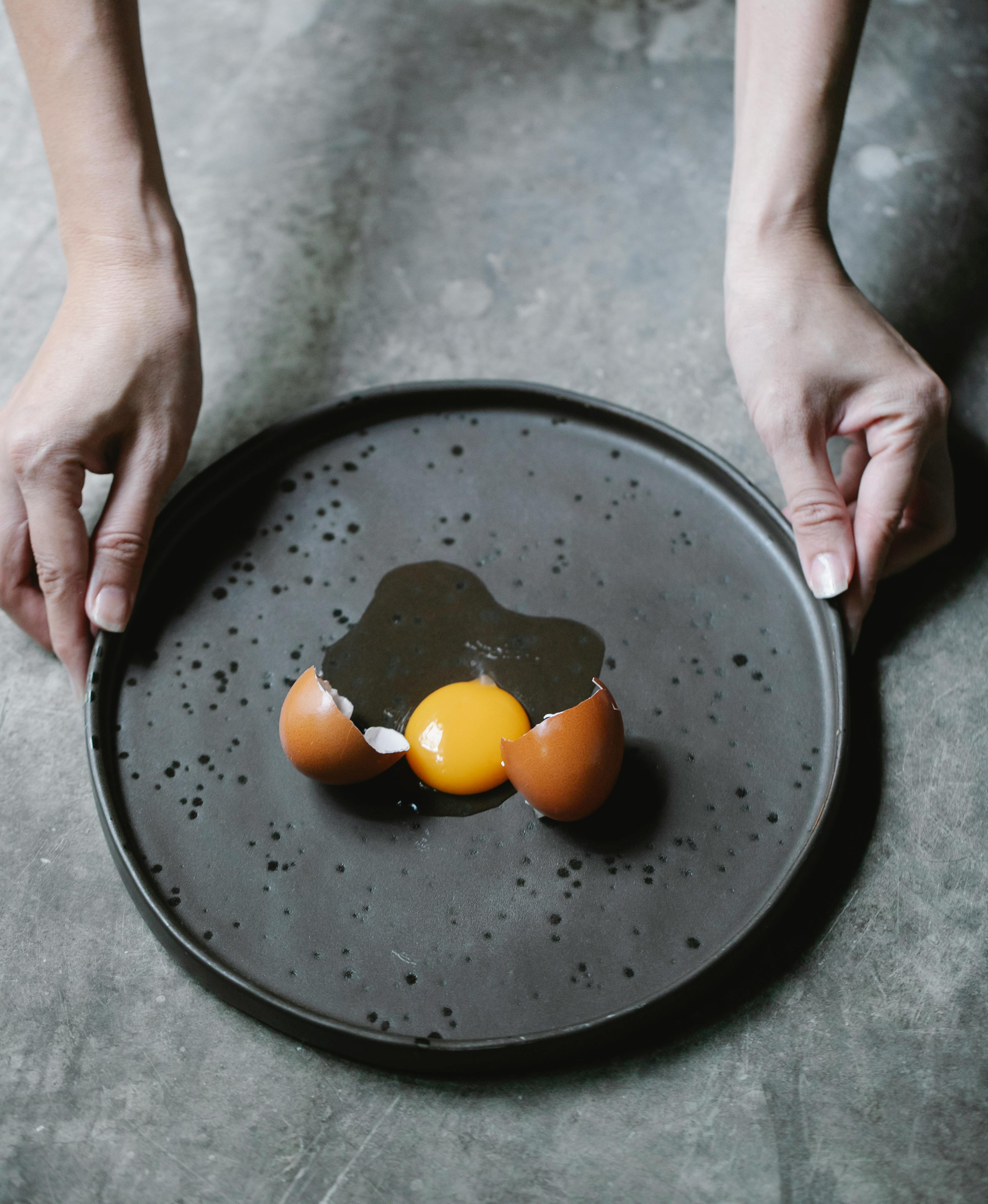 woman taking plate of broken eggs