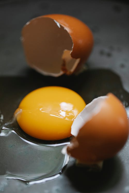 Broken eggs on frying pan in kitchen