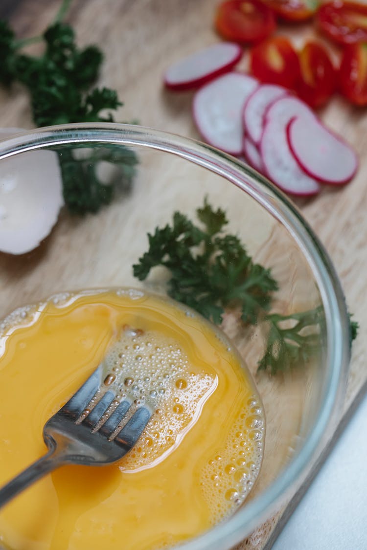 Whipped Eggs In Bowl Near Radish And Cut Cherry Tomatoes