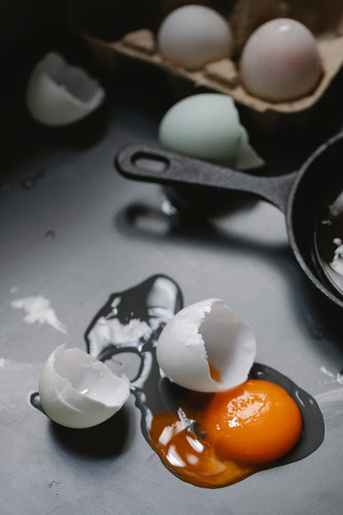 Broken egg scattered on table in kitchen