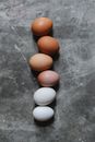 Top view of raw white and brown chicken eggs arranged in row on gray table in kitchen during Easter preparation