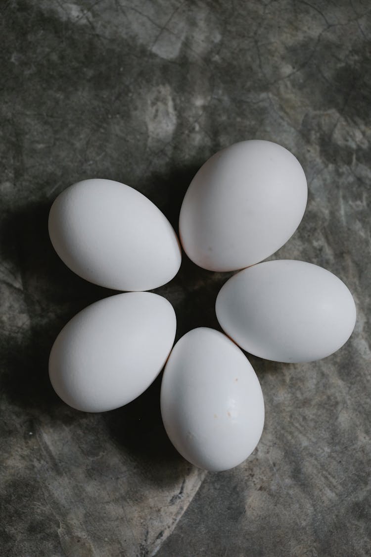 Set Of White Chicken Eggs Placed On Table