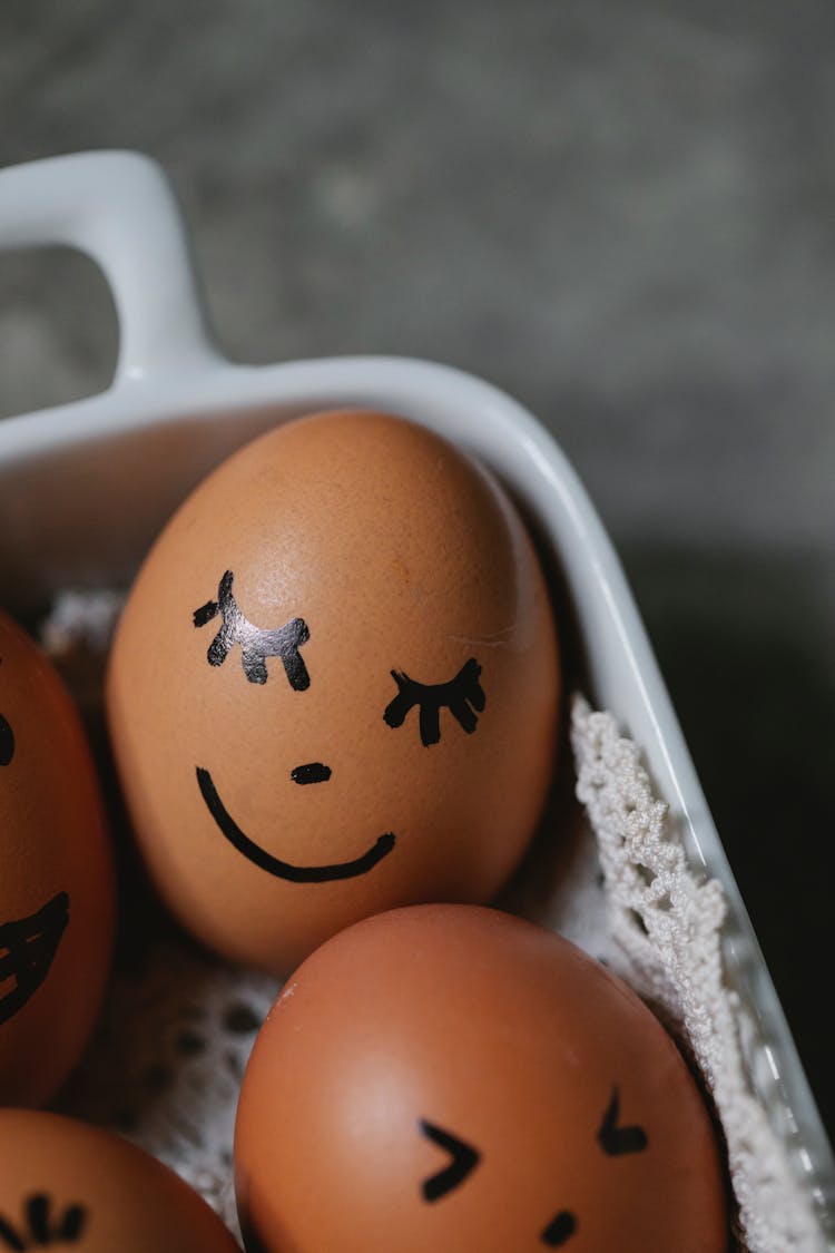 Chicken Eggs With Painted Faces Placed In Bowl