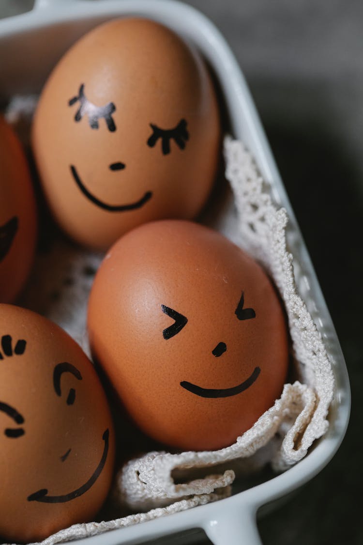 Heap Of Chicken Eggs With Painted Faces In Dish