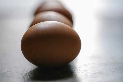 Free Row of brown chicken eggs placed on table in kitchen Stock Photo