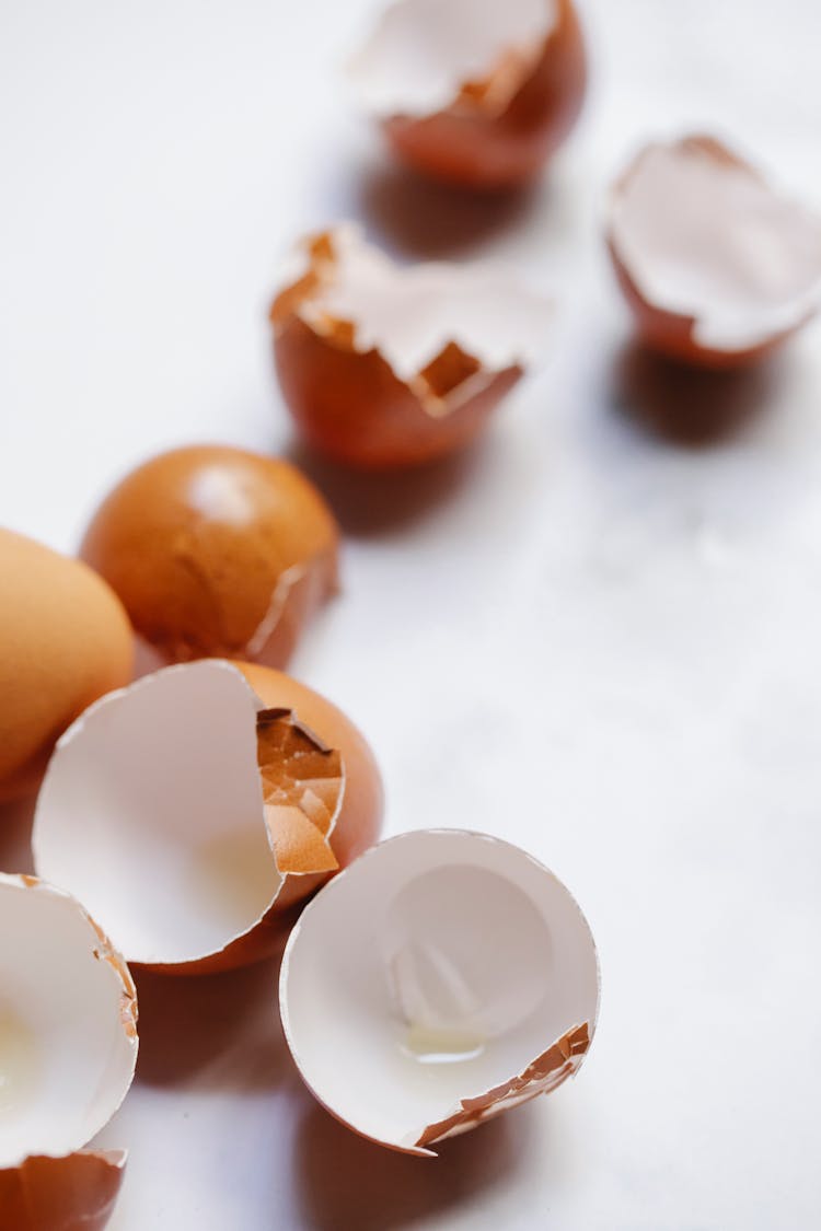 Broken Brown Eggshells Scattered On Table In Sunlight