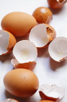 Whole and broken eggs scattered on table in kitchen
